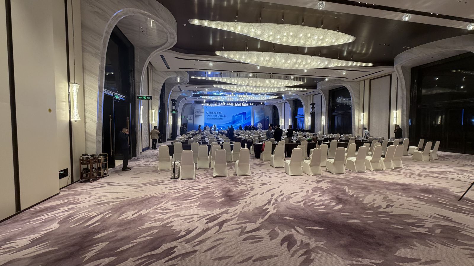 The hotel ballroom set up with rows of chairs and stage screens for the Eighteeth partner conference