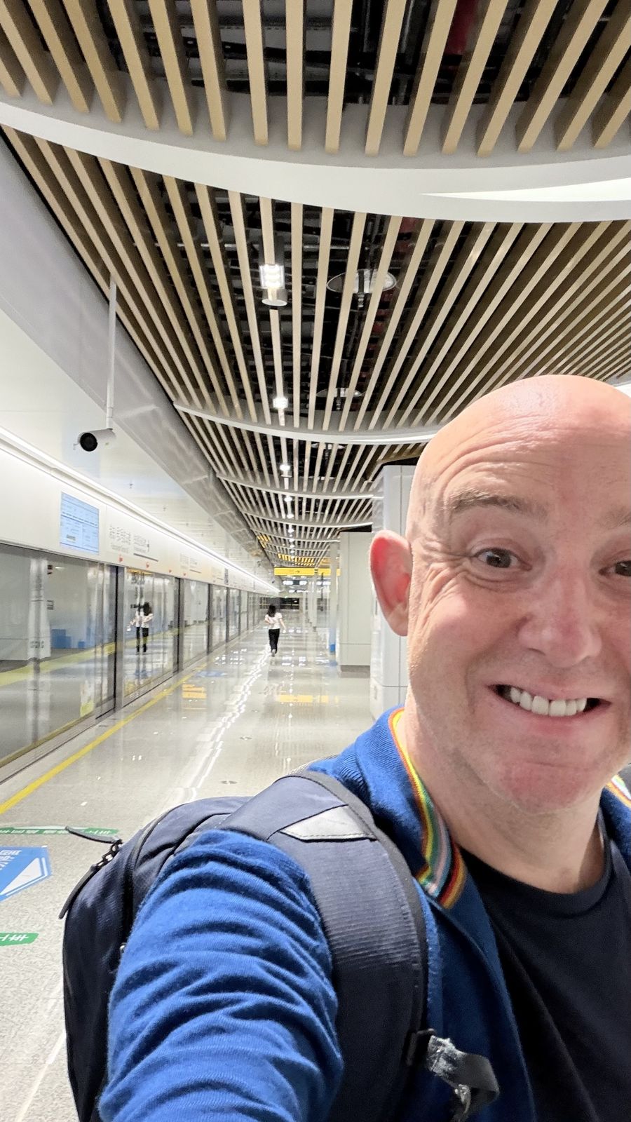Pete Donnelly smiling in a selfie on a modern platform in China