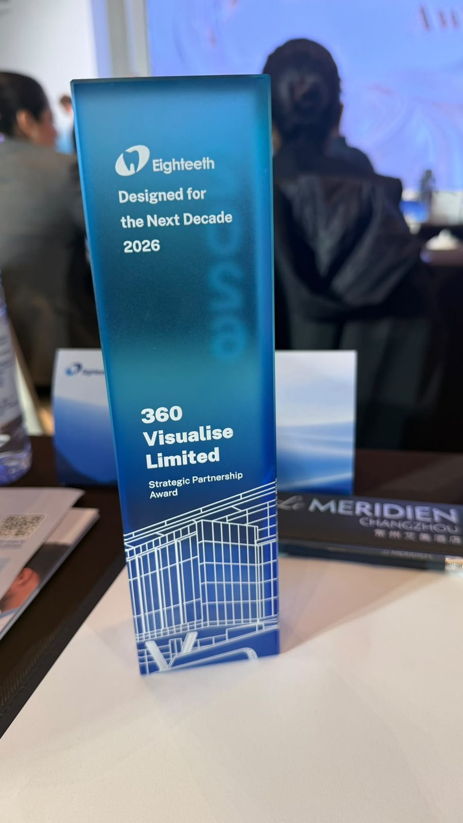 A glass award reading Eighteeth, Designed for the Next Decade 2026, 360 Visualise Limited, Strategic Partnership Award, on a table at Le Méridien Changzhou